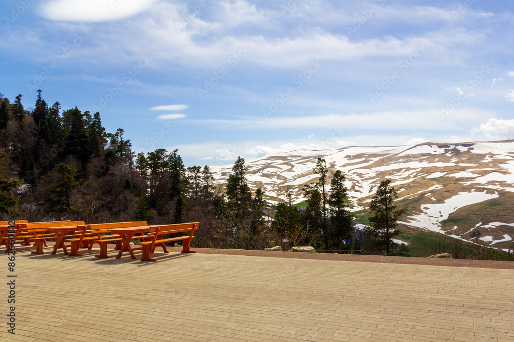 outdoor cafe area with benches and tables overlooking the Lago Naki mountain plateau in Adygea