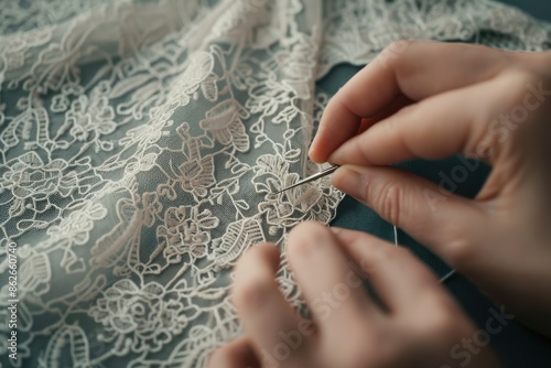 Close-up of hands stitching intricate lace fabric with a needle, showcasing detailed craftsmanship and delicate textile work.