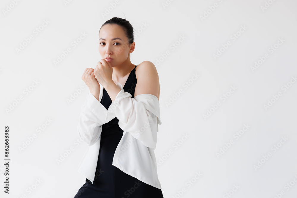 Stylish asian woman in black jumpsuit and shirt posing isolated on grey Stylish asian woman in black jumpsuit and shirt posing isolated on grey