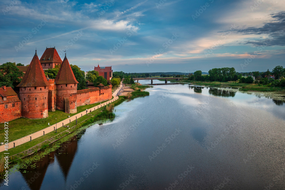 Castle of theTeutonic Order in Malbork by the Nogat river at sunset. Castle of theTeutonic Order in Malbork by the Nogat river at sunset.
