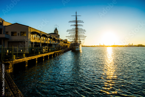 View of Fishing Boat, Aloha Tower at sunset with calm water, serene atmosphere, and historic landmark, Hawaii, United States. photo