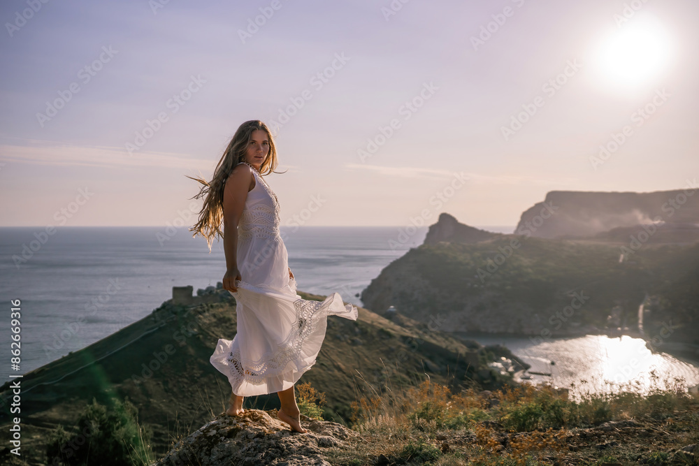 A woman in a white dress stands on a hill overlooking the ocean. The scene is serene and peaceful, with the woman's dress billowing in the wind. The combination of the ocean. A woman in a white dress stands on a hill overlooking the ocean. The scene is serene and peaceful, with the woman's dress billowing in the wind. The combination of the ocean.