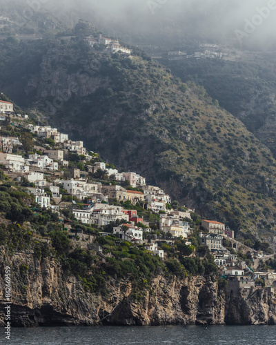 View of colorful cliffside town overlooking Mediterranean Sea and mountains, Amalfi Coast, Italy.