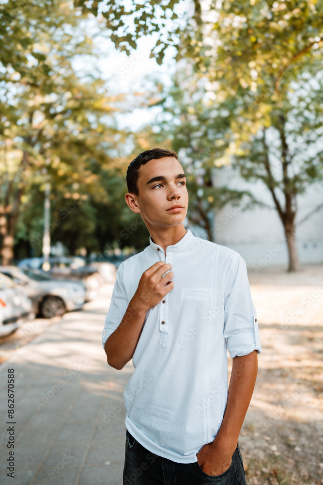 Handsome fashionable teenager standing on city street and posing. Handsome fashionable teenager standing on city street and posing.