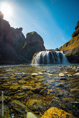 View of Clear Waterfall with Rock Formations and Stream, Stjornarfoss, Kirkjubaejarklaustur, Iceland. photo