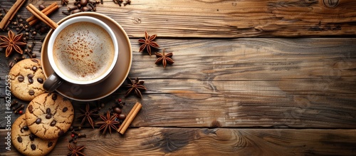 Top view of a cup of coffee and cookies on a wooden background with spices and decor, in retro style, featuring a blank area for text, ideal as a copy space image.