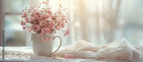 A romantic wedding concept depicted with a white mug filled with pink flowers, set on lace cloth against a soft, window-lit background, offering copy space for a letter or wallpaper. photo