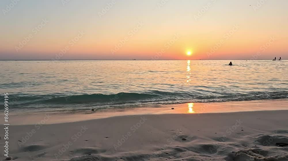 Beautiful sunset on a paradise island on Maldives, couple paying on the background Beautiful sunset on a paradise island on Maldives, couple paying on the background
