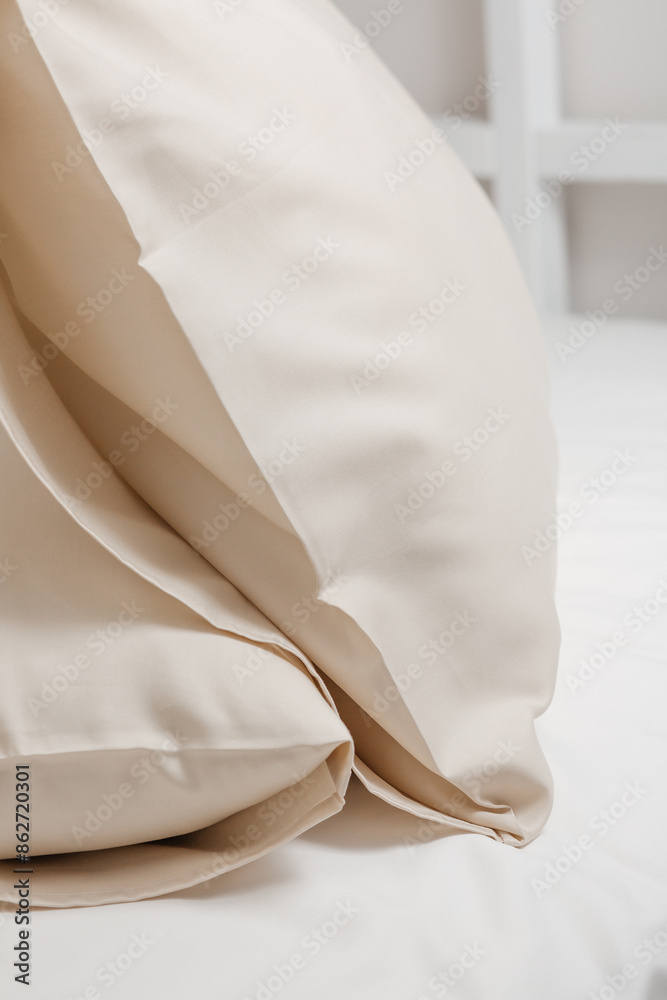 Beige satin (lyocell, silk, polyester) pillowcases on the bed. Home textile. Beige satin (lyocell, silk, polyester) pillowcases on the bed. Home textile.