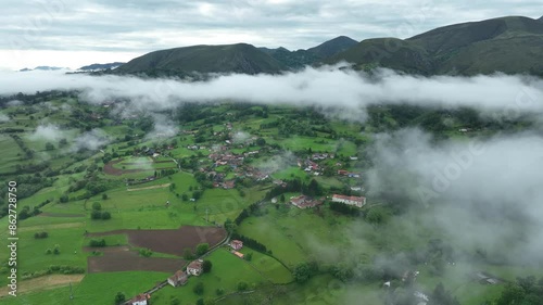 Aerial view of picturesque village surrounded by lush mountains and fields, Infiesto, Asturias, Spain. photo