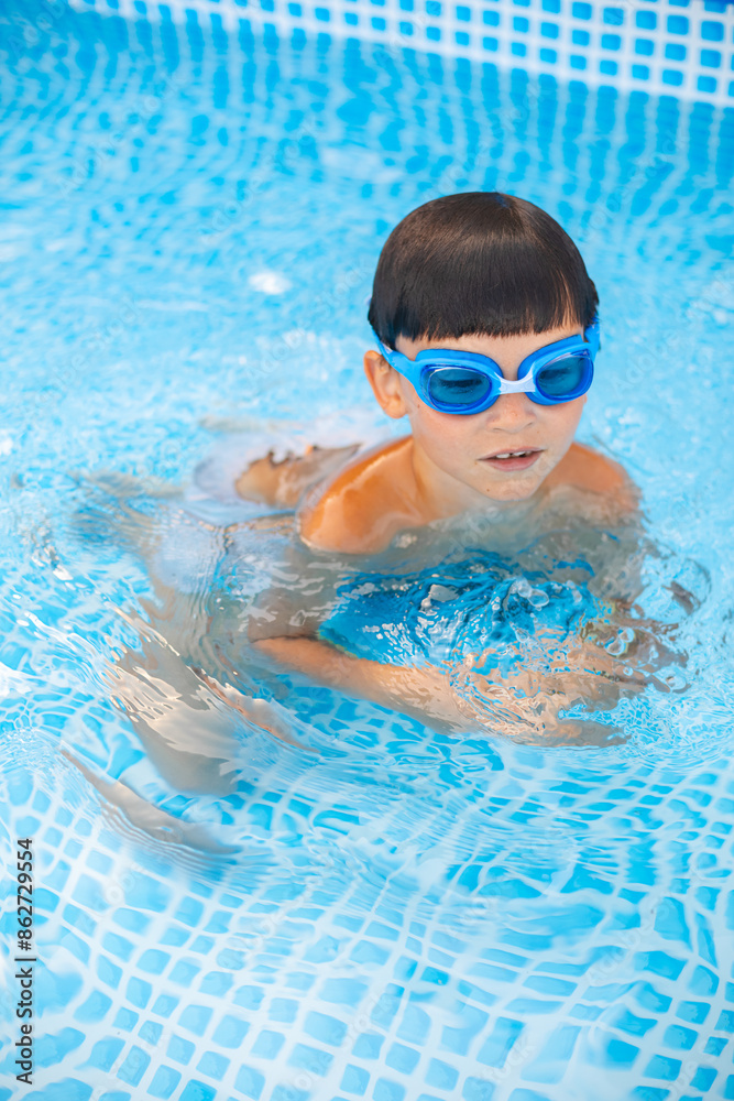 Naklejka premium Boy in glasses chill on water in swimming pool outdoor. Chill, rest and relax. Summertime vacation.