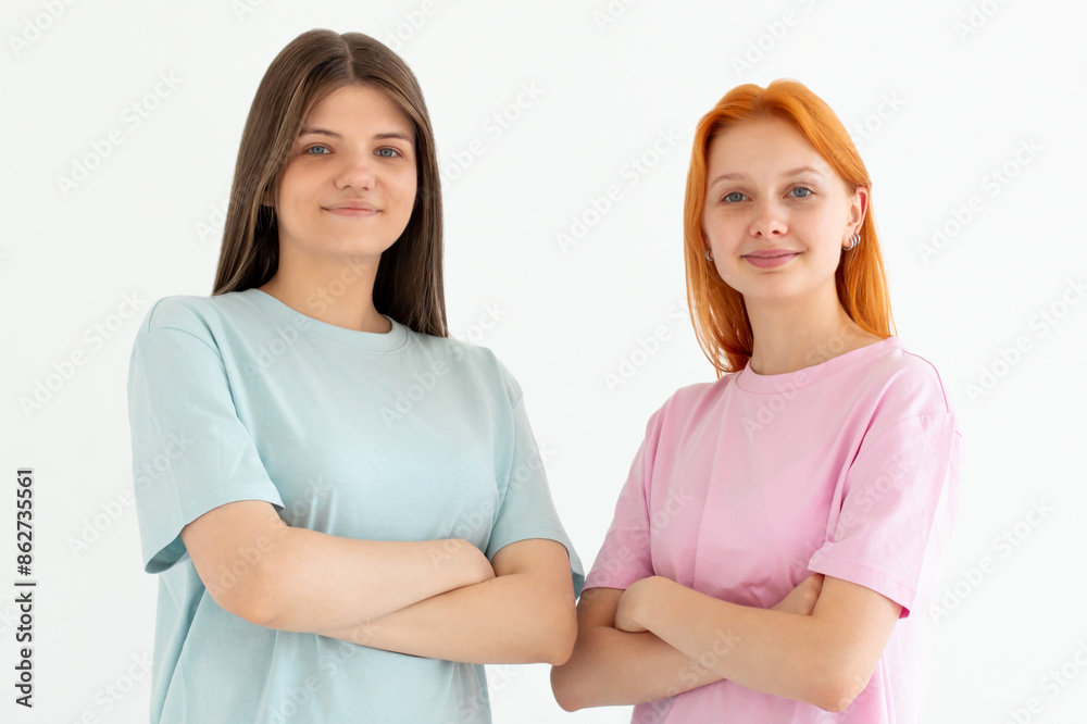 Young friends two women they wear blue and pink t-shirt casual clothes together hold hands crossed folded isolated on white background. Lifestyle concept Young friends two women they wear blue and pink t-shirt casual clothes together hold hands crossed folded isolated on white background. Lifestyle concept