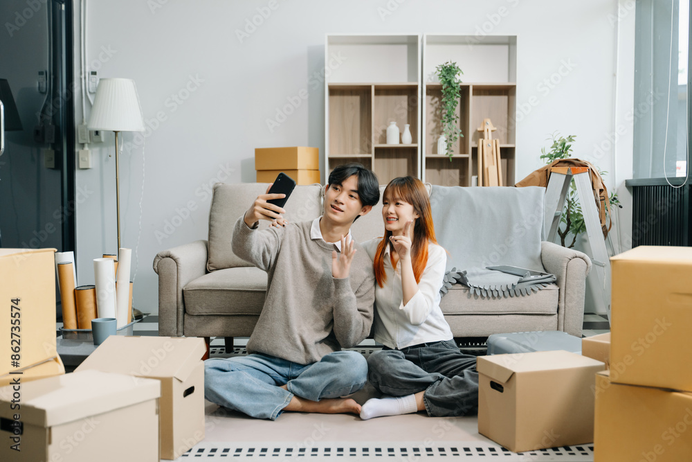 Happy asian young attractive couple man and woman with big boxes moving into a new house, new apartment