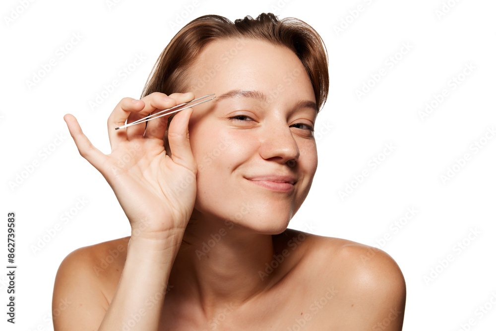 Young woman with short brown hair smiles while holding tweezers near her eyebrow, as if grooming it against white studio background. Concept of youth, beauty and fashion, cosmetic product, dermatology Young woman with short brown hair smiles while holding tweezers near her eyebrow, as if grooming it against white studio background. Concept of youth, beauty and fashion, cosmetic product, dermatology
