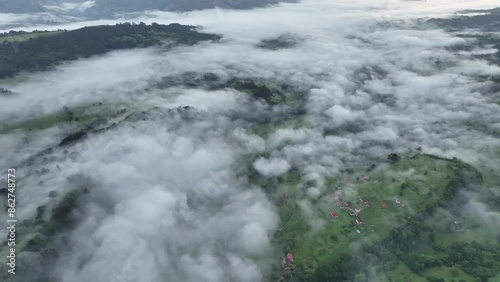 Aerial view of misty forest-covered hills and serene valley, Infiesto, Asturias, Spain. photo