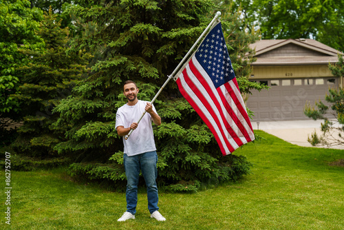 Cuadro en lienzo Young handsome man with USA flag in park. 4 July celebration
