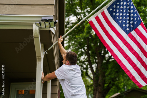 Young man put USA flag on his resedential area at house photo