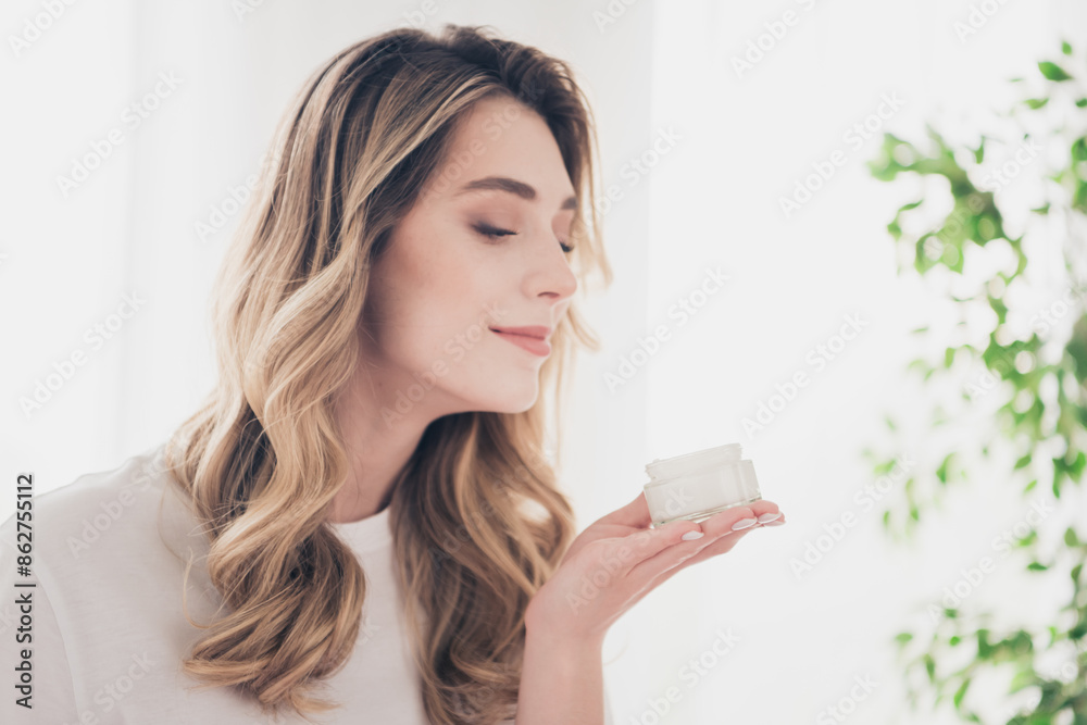 Photo of girl hold cream jar product smell in day light room indoors Photo of girl hold cream jar product smell in day light room indoors