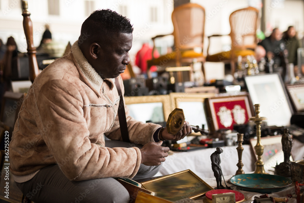 South African man selects antiques at a flea market