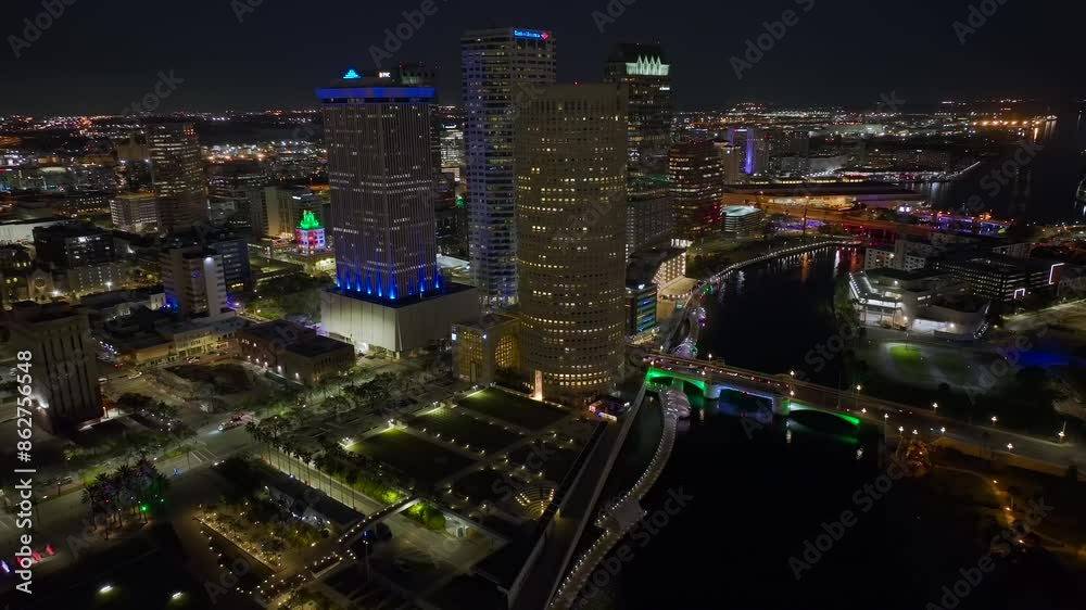 Brightly illuminated skyscraper buildings and traffic in downtown district of Tampa city in Florida, USA. American megapolis with business financial district at night Brightly illuminated skyscraper buildings and traffic in downtown district of Tampa city in Florida, USA. American megapolis with business financial district at night