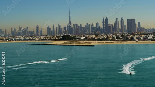 Aerial view of Dubai skyline at sunset with yacht and motor boat, Dubai, United Arab Emirates.