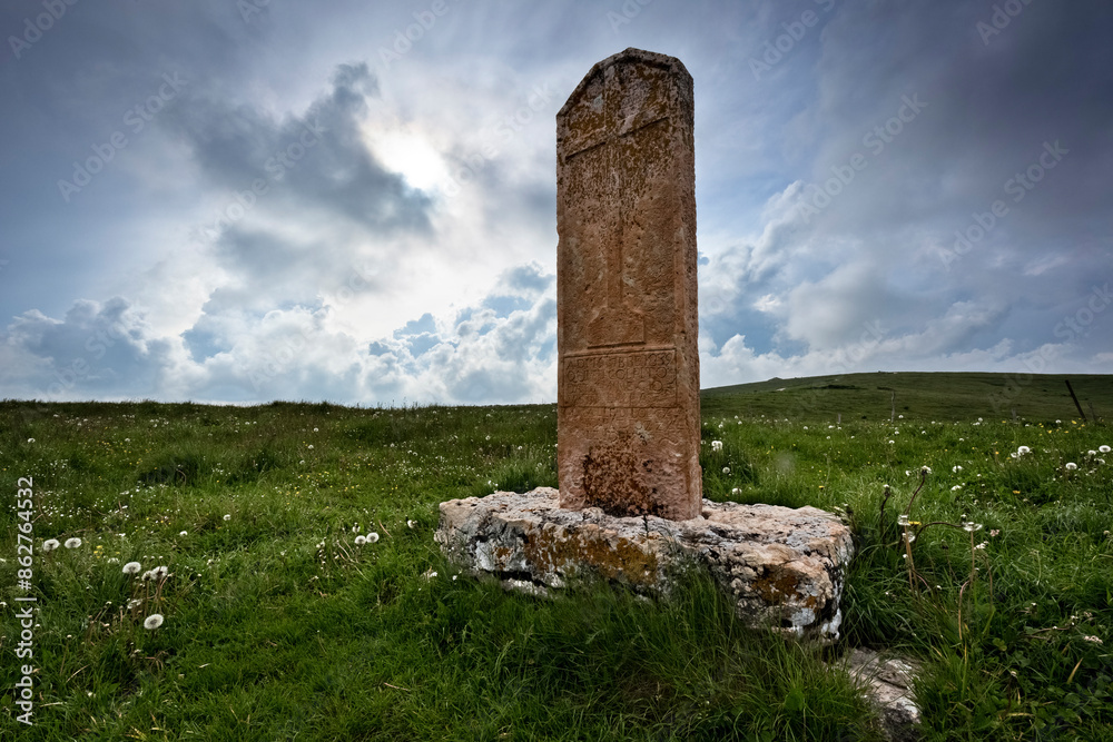 The Norderi cross: ancient religious stone among the pastures of Lessinia. Velo Veronese, Veneto, Italy.