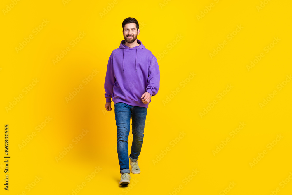 Naklejka premium Full size photo of handsome young guy walking model wear trendy violet outfit isolated on yellow color background