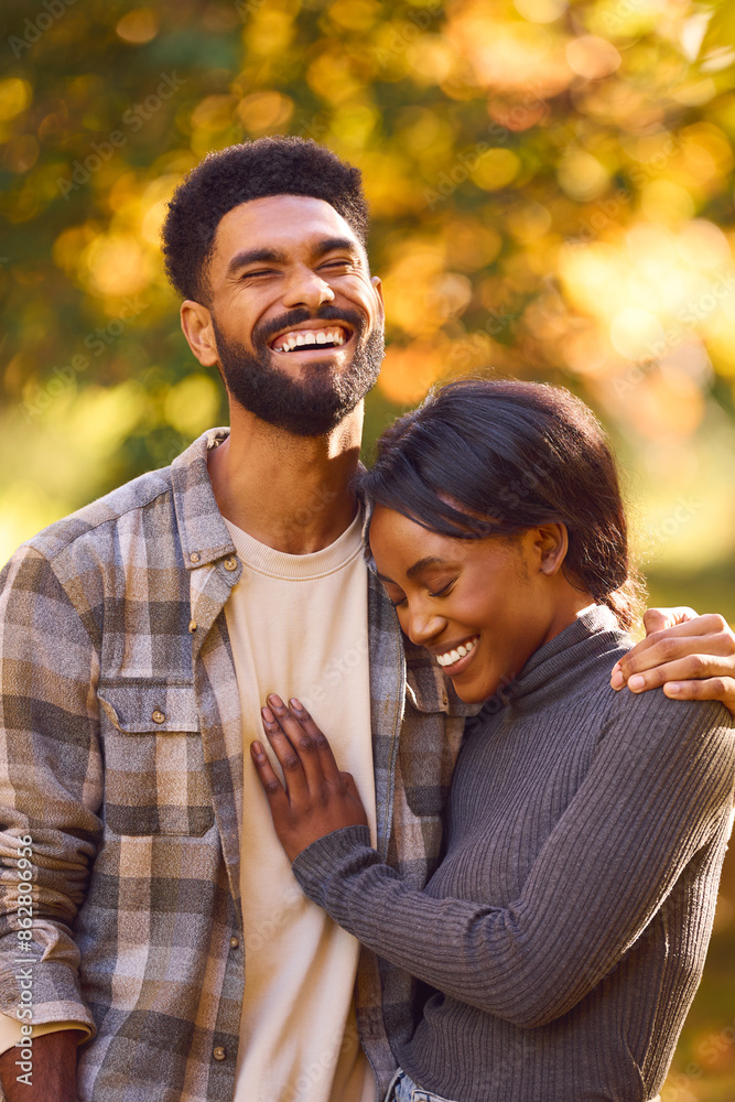 Loving Young Couple Hugging Against Background Of Autumn Leaves In Garden Or Countryside Loving Young Couple Hugging Against Background Of Autumn Leaves In Garden Or Countryside