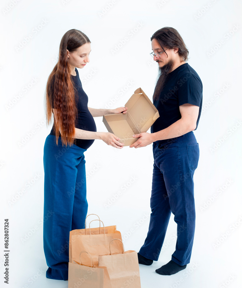 Portrait happy young pregnant woman and her husband with shopping bags and touching her big belly isolated on white background. Pregnancy shopping concept happy young family with shopping bags