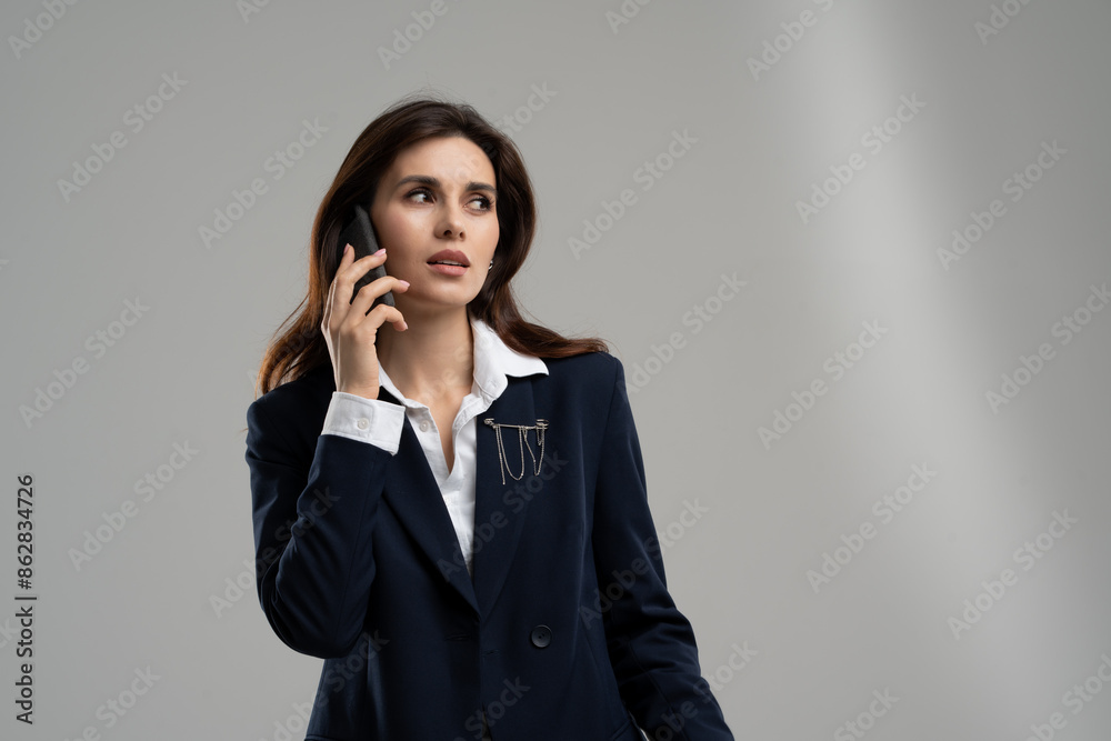 Businesswoman in formal attire with long hair talking on smartphone Businesswoman in formal attire with long hair talking on smartphone