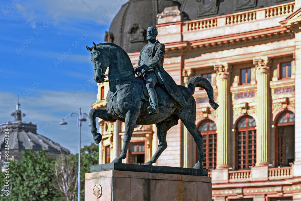 Obraz premium The equestrian statue of king Carol I on Piața Palatului (Revolution square) in front of the library of 