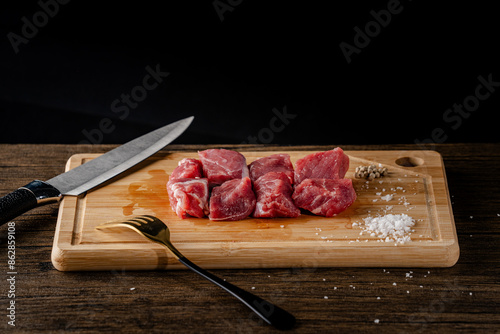 A slice of beef on a cutting board with a knife and fork