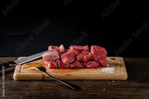 A slice of beef on a cutting board with a knife and fork