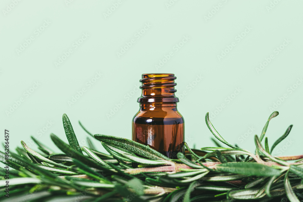 A bottle of essential oil is sitting on a green leaf A bottle of essential oil is sitting on a green leaf