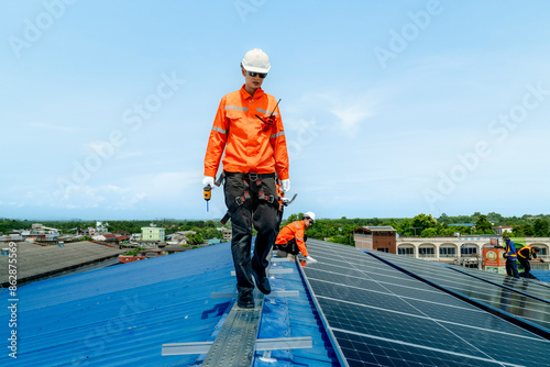 engineer man inspects construction of solar cell panel or photovoltaic cell by electronic device. Industrial Renewable energy of green power. factory worker working on tower roof. © ultramansk