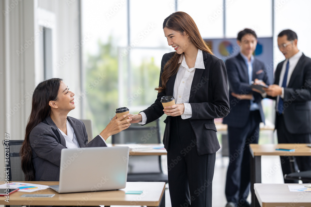 Two Asian Business Women Enjoying Coffee in Modern Office Setting – Professional Work Environment, Collaboration, and Corporate Lifestyle Captured in a Casual and Relaxed Break Time Moment Two Asian Business Women Enjoying Coffee in Modern Office Setting – Professional Work Environment, Collaboration, and Corporate Lifestyle Captured in a Casual and Relaxed Break Time Moment