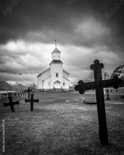 A Moody Black and White Image of a Small Church with Grave Markers