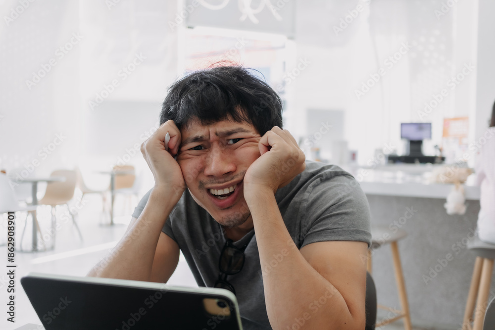 Unhappy asian Thai man have no idea on working laptop in bright cafe, get stressed and go crazy. Unhappy asian Thai man have no idea on working laptop in bright cafe, get stressed and go crazy.