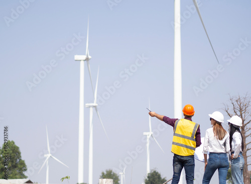 A group of engineers and architects are consulting. About taking care of wind turbines For a sustainable environment