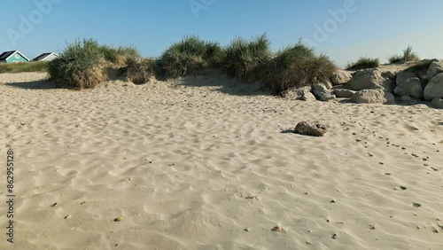 4k video of drone flying toward and over beach huts from sea in Mudeford, Dorset