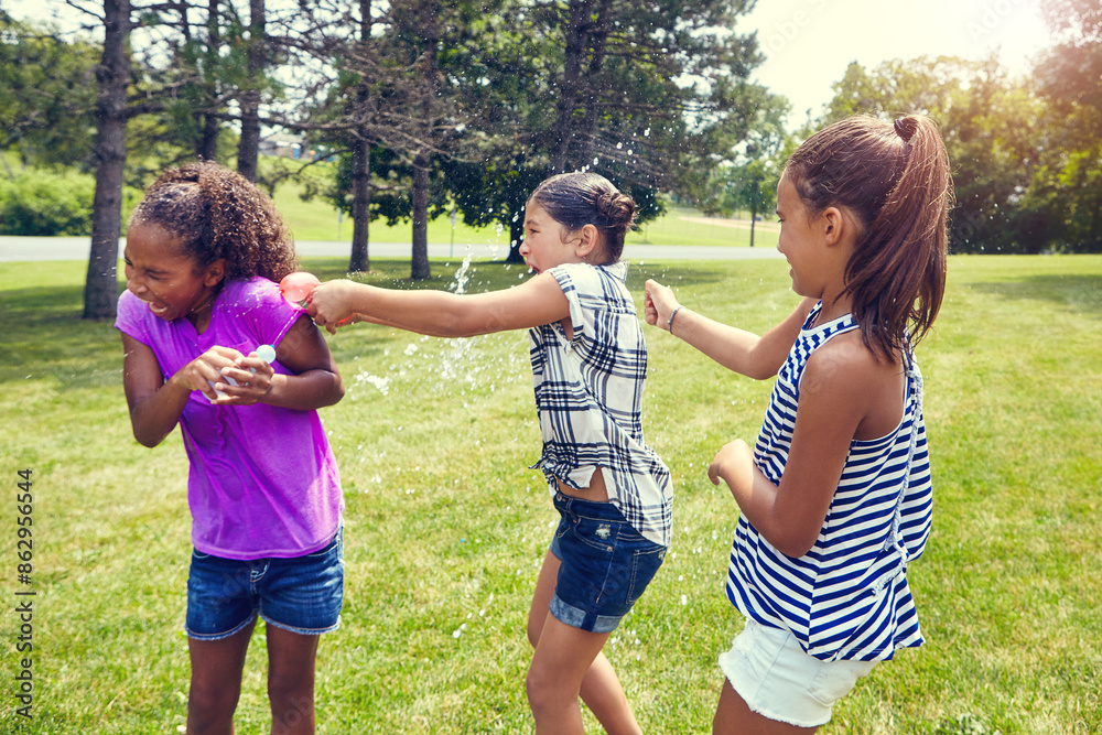 Fototapeta premium Water, balloon and girl children in backyard with game, bonding and outdoor holiday together in garden. Playing, kids and happy friends on grass with fun, energy and splash on summer vacation in park