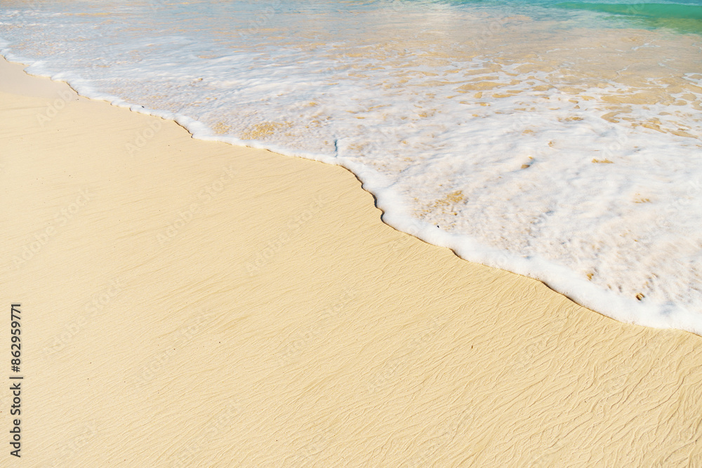 A sandy beach with waves crashing, showcasing the beauty of water and nature A sandy beach with waves crashing, showcasing the beauty of water and nature