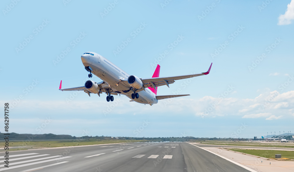 White Passenger plane fly up over take-off runway from airport - El Prat-Barcelona airport. This airport was inaugurated in 1963 - Barcelona, Spain