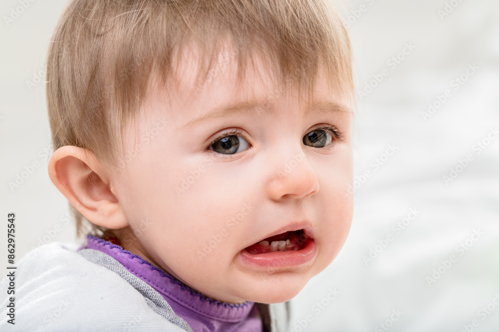 Baby girl making a funny face showing growing teeth Baby girl making a funny face showing growing teeth