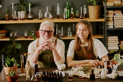 Fotografie Senior perfumer sitting at his workplace with huge number of perfume samples and