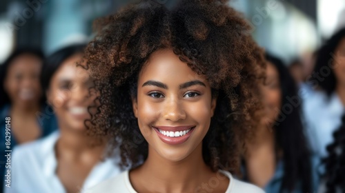 Confident black woman smiling with colleagues in background. Portrait of a happy African American businesswoman leading a diverse team, showcasing leadership and workplace diversity.
