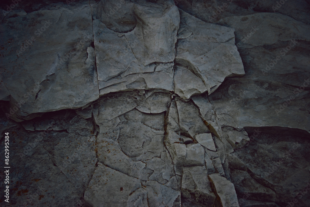 Naklejka premium Black rock texture, darkened background of a black rock wall