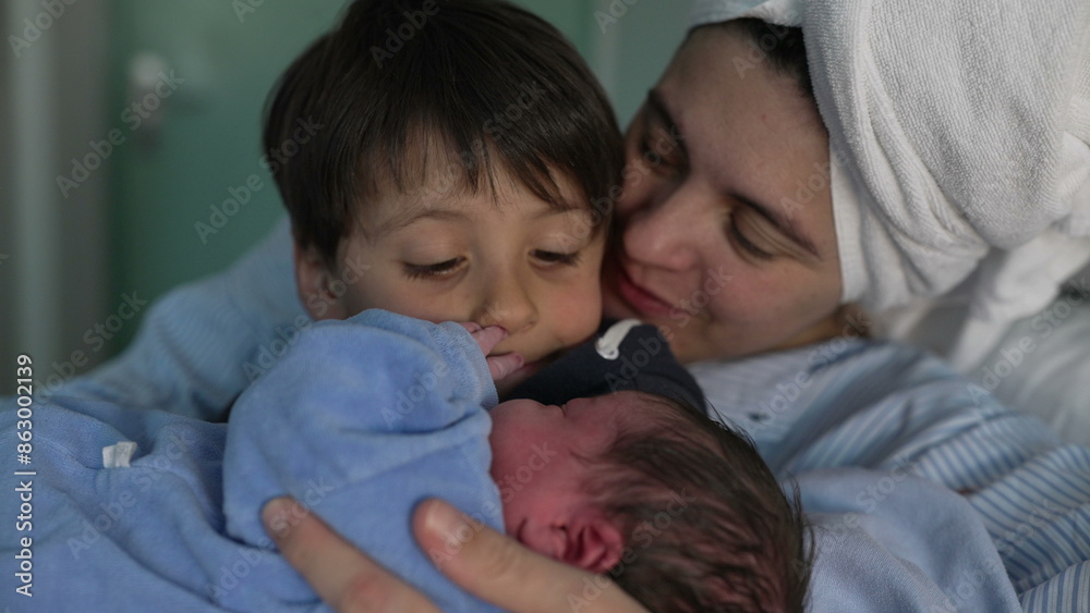 Newborn Introduction to Sibling at Hospital - Young Brother Cradles New Baby as Mother Observes, Celebrating First Family Bonding Moment Newborn Introduction to Sibling at Hospital - Young Brother Cradles New Baby as Mother Observes, Celebrating First Family Bonding Moment