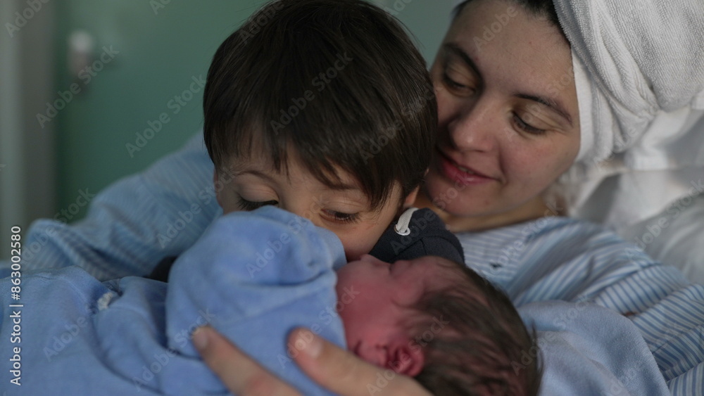 Newborn Introduction to Sibling at Hospital - Young Brother Cradles New Baby as Mother Observes, Celebrating First Family Bonding Moment Newborn Introduction to Sibling at Hospital - Young Brother Cradles New Baby as Mother Observes, Celebrating First Family Bonding Moment
