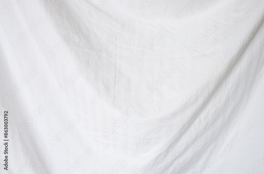 Fototapeta premium Top view of wrinkles on an unmade bed sheet after waking up in the morning.